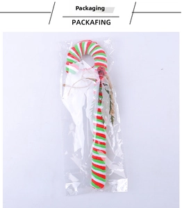 Close-up of candy cane ornament with red and green stripes and a small bell