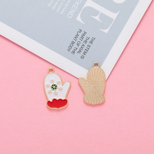 Detailed view of Christmas glove alloy charms with snowflake patterns and red enamel
