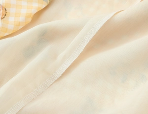 Dettaglio macro di cuciture sottili e finitura dei bordi su un vestito in chiffon leggero