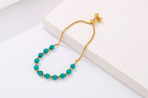 Vue détaillée d'un bracelet réglable en maille miroir dorée avec perles de turquoise