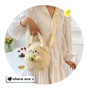 Detail of cute beige plush animal crossbody bag with avocado motif and adjustable strap