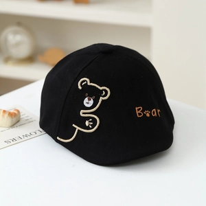 Detail shot of a black cotton kids' beret with cute bear embroidery on a white table