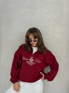 Detail view of burgundy half-zip sweatshirt with British Heritage embroidery and collar