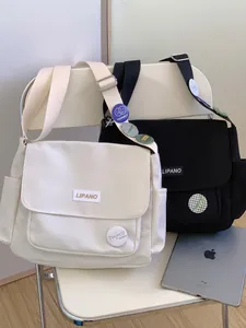 Japanese style canvas messenger bag in black and beige with vintage badges and wide strap