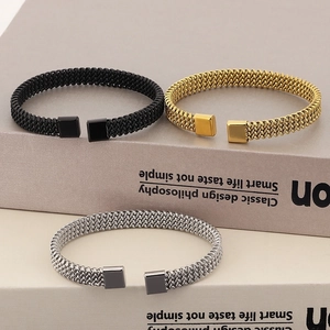 Gedetailleerde weergave van geweven roestvrijstalen armbanden in zwart, goud en zilver