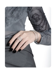 Close-up of geometric hollow silver ring and bracelet set with sparkling crystals