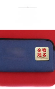 Macro shot of gold square metal pin with embossed success characters on blue canvas bag