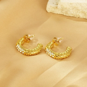 Makro-Detail von 18K Gold C-Ohrringen mit Schuppentextur und eingesetzten Zirkonia