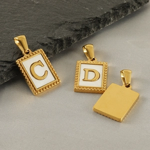 Goldener rechteckiger Buchstabenanhänger mit weißem Inlay C und D auf dunklem Schiefer