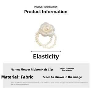 Detail of off-white fabric camellia hair tie featuring dual faux pearl chain accents