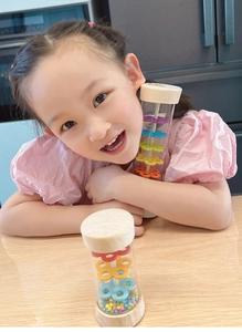 Macro view of colorful beads inside a wooden rainmaker tube toy for kids' early education