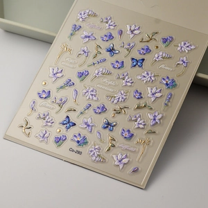 Dettaglio degli adesivi 5D per unghie con fiori viola e farfalle blu in rilievo