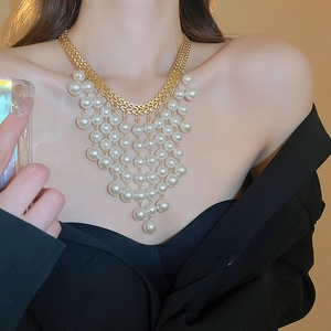 Detail of layered gold fringe necklace featuring elegant white faux pearl tassels for women