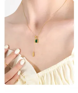 Detail of emerald zircon pendant with gold BABY bar on adjustable tassel chain