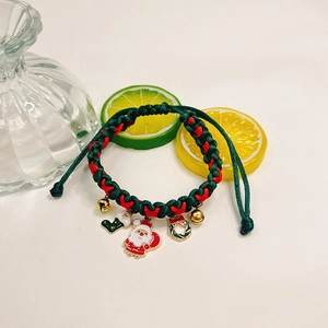 Detail eines Weihnachts-Haustierhalsbands mit Weihnachtsmann und Glocken auf Kordel