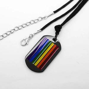 Detail of black metal dog tag pendant with rainbow flag design and black cord necklace