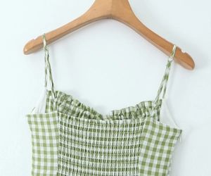 Close-up of green checkered floral dress with thin straps and smocked bodice detail