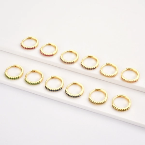 Macro detail of S925 sterling silver gold hoop earrings set with colorful cubic zirconia
