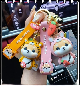 Detail of cute silicone Shiba Inu keychains with dragon costumes held in hand in a car