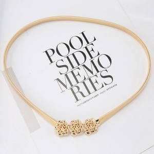 Detail of gold metal elastic spring belt featuring three exquisite decorative roses
