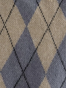 Detailed macro view of the soft argyle knit fabric texture with grey and khaki patterns