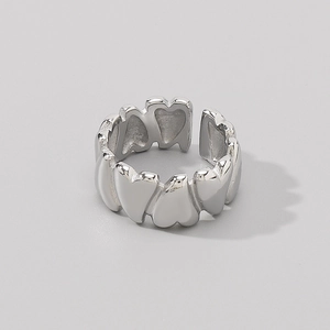 Macro detail of irregular silver heart pattern on a minimalist open stainless steel ring