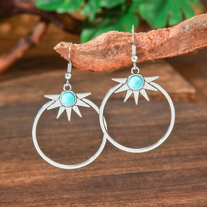 Detail view of Bohemian teardrop earrings with turquoise stones on natural wood branches