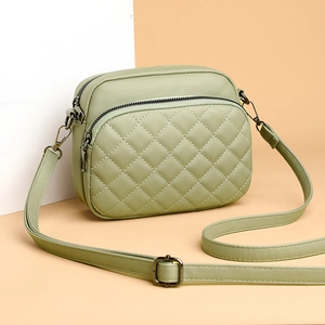 Fashionable light green quilted crossbody bag with dual zippers and adjustable strap