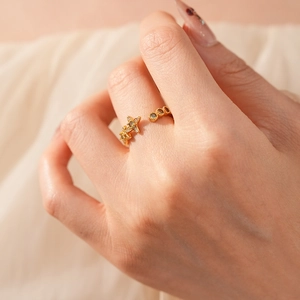 Détail macro d'une bague étoile en or vintage avec zircons portée au doigt