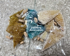 Miniature sisal Christmas trees in gold, green and white with wooden bases inside packaging
