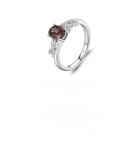 Macro detail of S925 silver ring featuring an oval garnet stone and vintage vine hollow pattern
