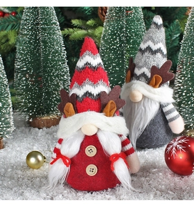 Gros plan de gnomes de Noël gris et rouges avec bois sur fond de neige festif
