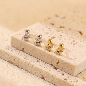 Close-up of gold and silver S925 sterling silver screw back earrings with sparkling zircon