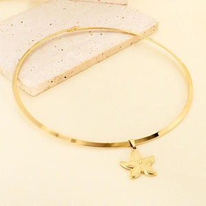 Detail of 18K gold-plated choker featuring a textured starfish pendant on a stone background
