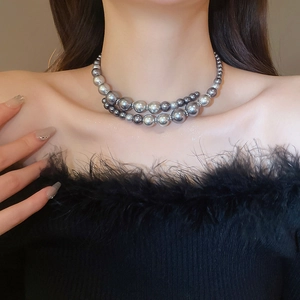 Detail view of double-layered gradient silver-grey pearl necklace on a model neckline