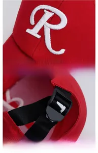 Detail of red baseball cap featuring white 3D letter R embroidery and adjustable back strap
