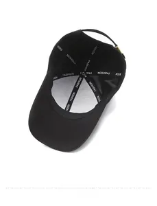 Interior detail of black baseball cap with FASHION logo tape and metal buckle closure