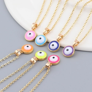Macro detail of colorful enamel evil eye pendants on gold chains in various vibrant colors