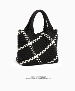 Close-up of retro woven tote bag featuring black and white geometric diamond patterns