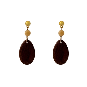Detail of geometric teardrop wood earrings with ivory resin beads and gold hooks