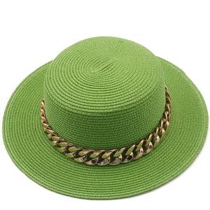 Detail of green straw boater hat featuring a stylish thick gold metal chain band