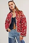 Street style outfit with red printed jacket, denim vest, and patchwork jeans detail