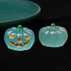 Macro shot of 3D glowing glass pumpkin figurines for Halloween with Jack-O-Lantern details
