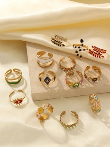 Detail of 18k gold plated open rings with colorful enamel floral and snake patterns