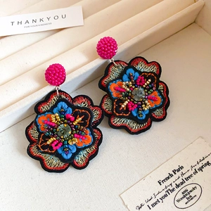 Detail of bohemian floral embroidery earrings with colorful beads and centered rhinestone