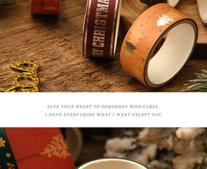 Detail of Christmas washi tape with gold foil Merry Christmas lettering on wood background