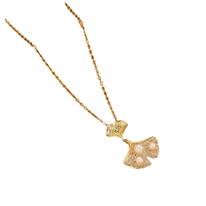 Elegant gold ginkgo leaf necklace with pearls and zircon crystals on a white background