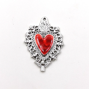 Detailed silver heart pendant with red enamel inlay and intricate skull and wing engravings