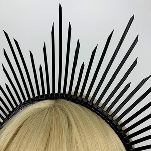 Close-up of black spiked crown headband with metallic details on blonde mannequin head