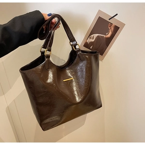 Detail of dark brown vintage tote bag in soft oil-wax leather with gold metal trim